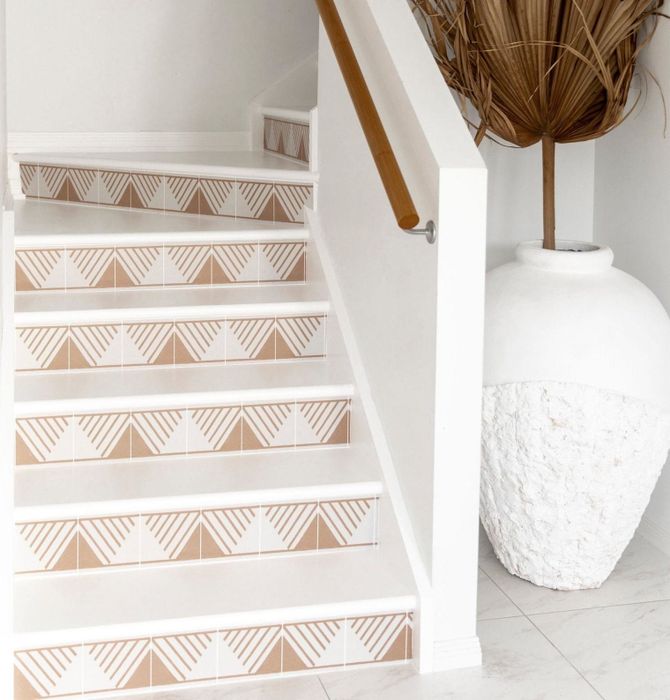 A tan triangle design with lines stickers on the vertical part of a set of stairs