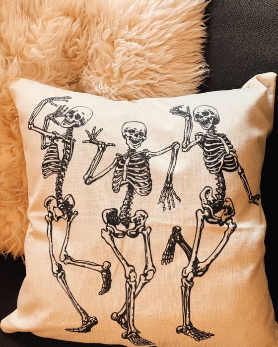 a close-up of one of the throw pillows featuring dancing skeletons