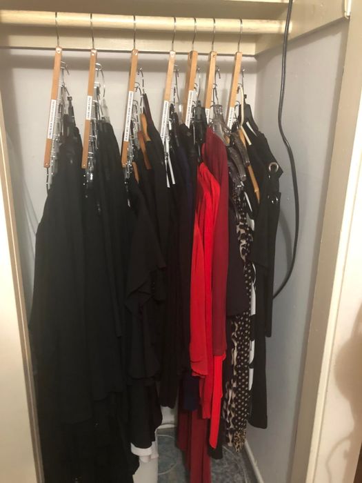 A neatly arranged closet with hangers showcasing clothing in an orderly fashion