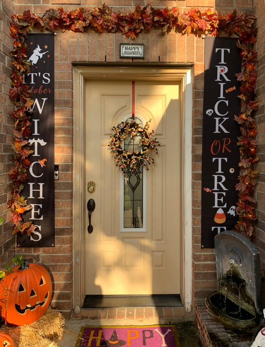 a front door decorated for Halloween, with banners on either side that say