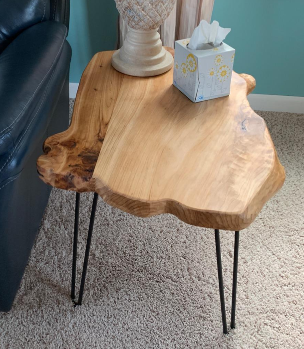 A photo from a reviewer showcasing the wooden side table, complete with a lamp and a box of tissues.