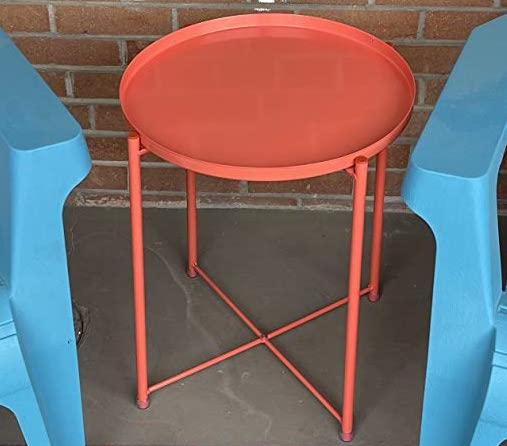 Reviewer photo of the red table on a patio beside two blue deck chairs.