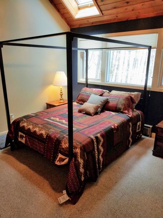 A reviewer's black canopy bed displayed in a stylish bedroom.