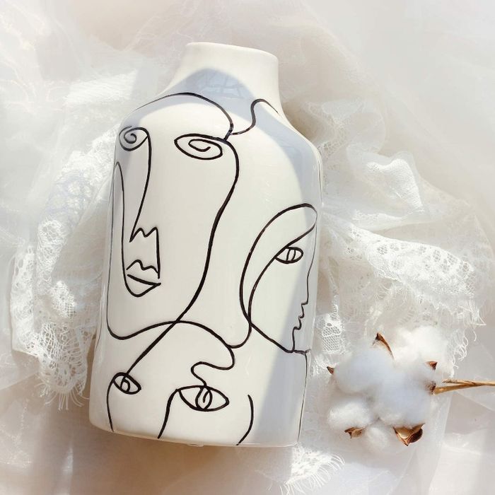 The vase elegantly displayed atop delicate lace fabric.