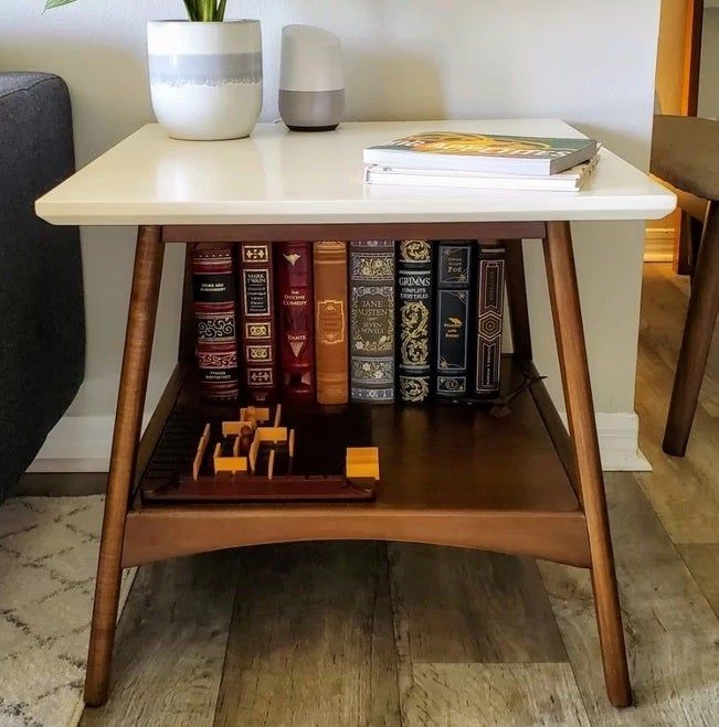 Reviewer photo of the white and wood end table, holding books and a vase.