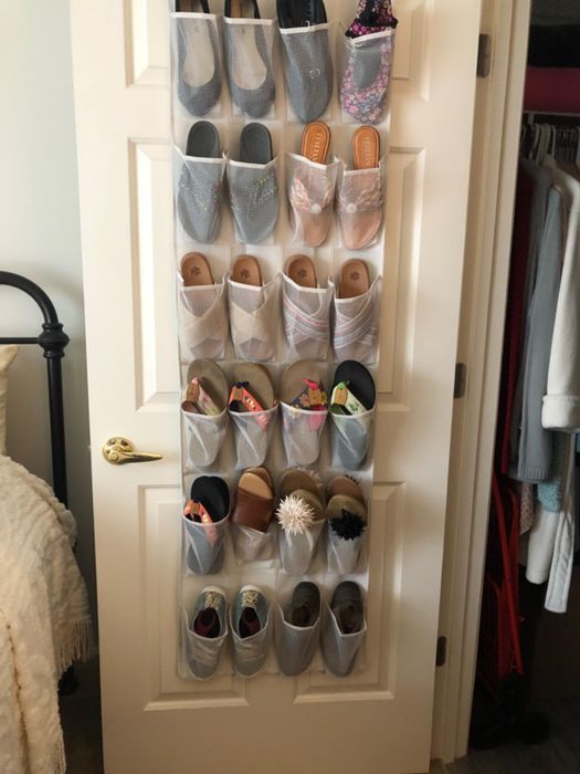 A shoe organizer mounted on a door, packed with shoes and miscellaneous small accessories