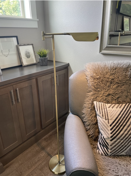 A reviewer’s lamp elegantly hangs over a comfy reading chair.