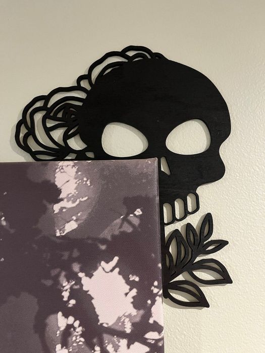 a skull corner sign positioned beside a painting