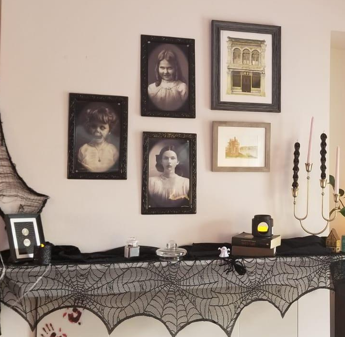 the three eerie Victorian portraits displayed as a gallery wall above a reviewer's fireplace mantle