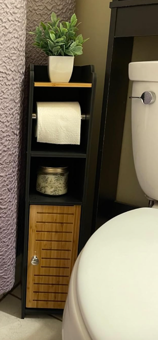 A reviewer's compact bathroom organizer in black and brown, complete with a cabinet and a built-in toilet paper roll.