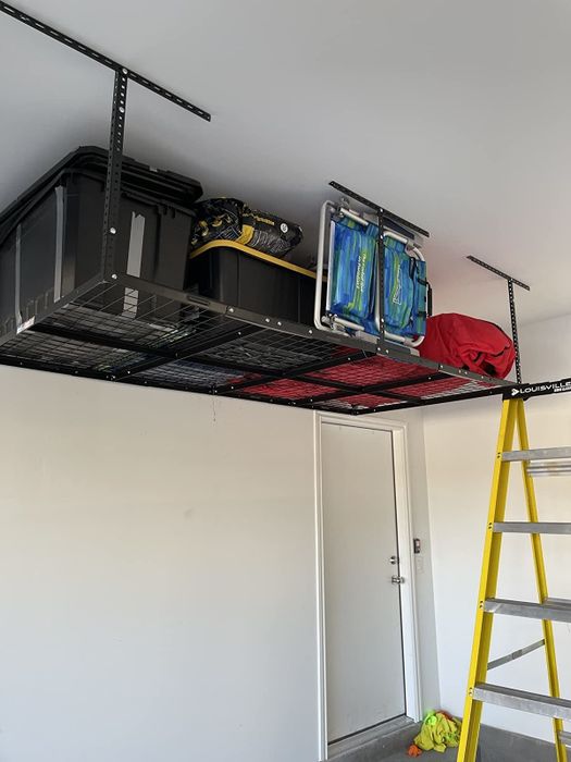 Another reviewer’s black shelving unit holding chairs and multiple storage bins.