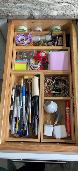 A reviewer’s drawer featuring bins that effectively organize their previously cluttered junk.