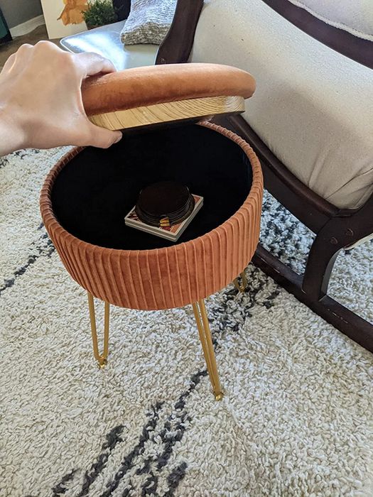 a different reviewer showcasing the inside storage of the ottoman