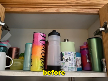 a reviewer's cabinet cluttered with water bottles before using the organizer