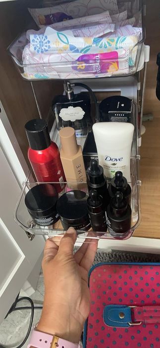 A reviewer demonstrating the bottom drawer of the two-tiered organizer being pulled out.