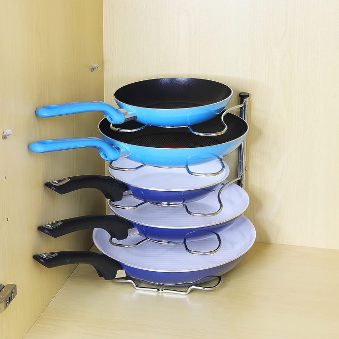 A collection of five pans in various sizes neatly arranged on a rack.