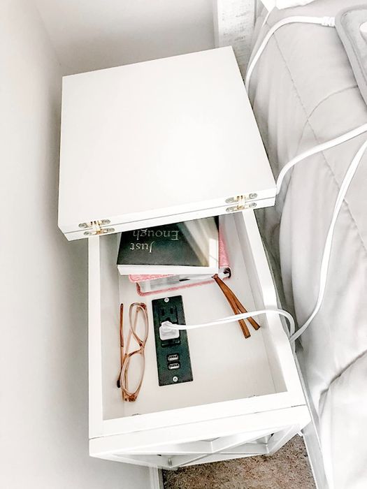 The reviewer demonstrates the interior of the table, highlighting the built-in plug outlets.