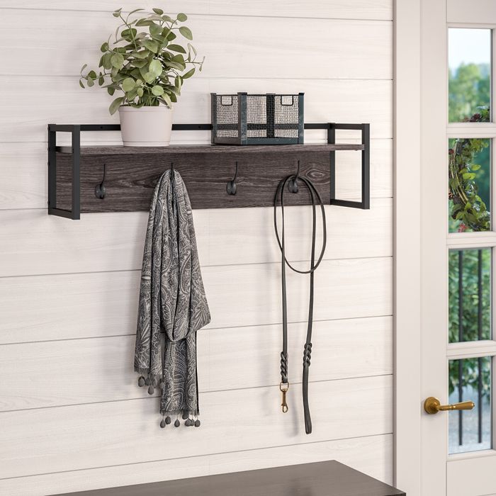 a gray wall-mounted coat rack with a shelf and four hooks