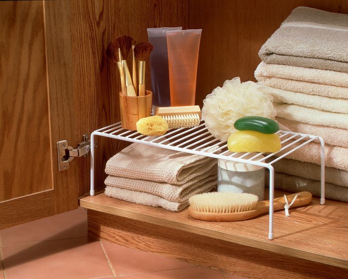 white metal shelf inside a cabinet organizing bathroom supplies