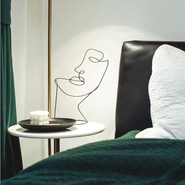 a black wire sculpture shaped like an abstract face