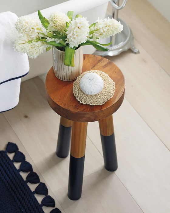 a close-up of the stool with a vase of flowers placed on top