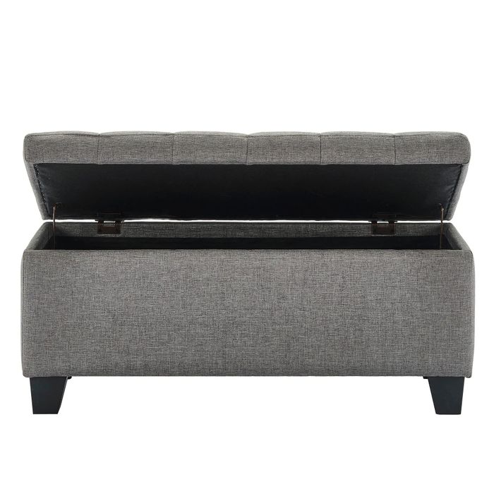 A gray storage ottoman featuring an open lid design