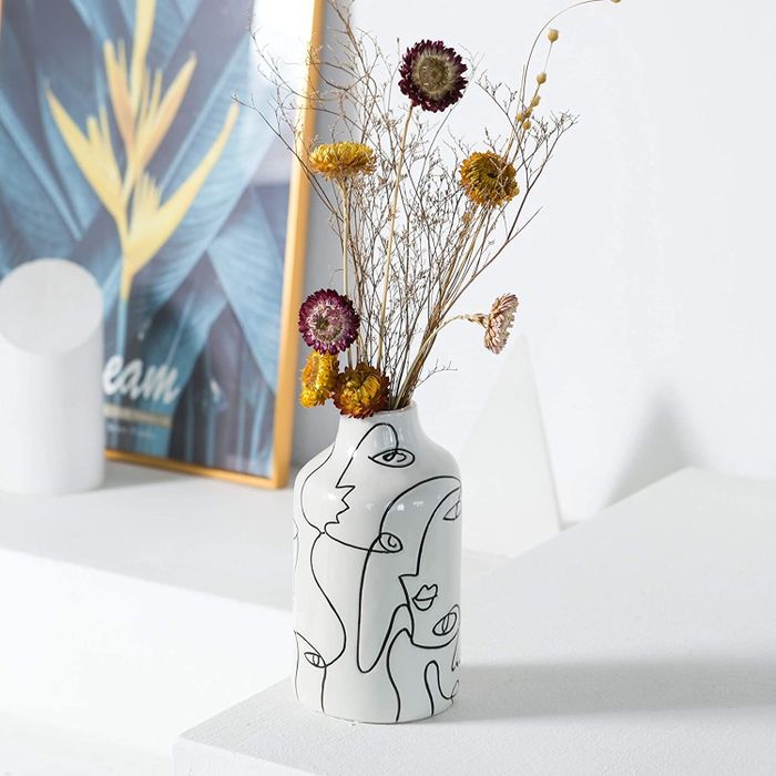 the white etched vase holding a bouquet of dried flowers