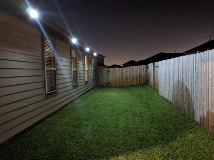 The four lights casting a bright glow in the backyard during the night
