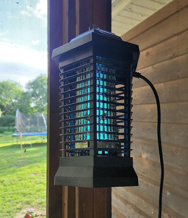 A reviewer's photo of the bug zapper lantern hanging from a patio