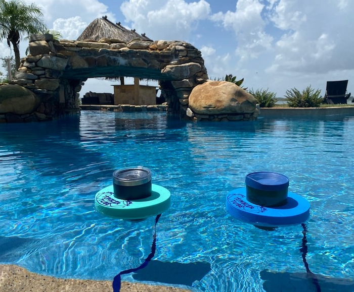 Two floating tubes around tumbler cups in a pool
