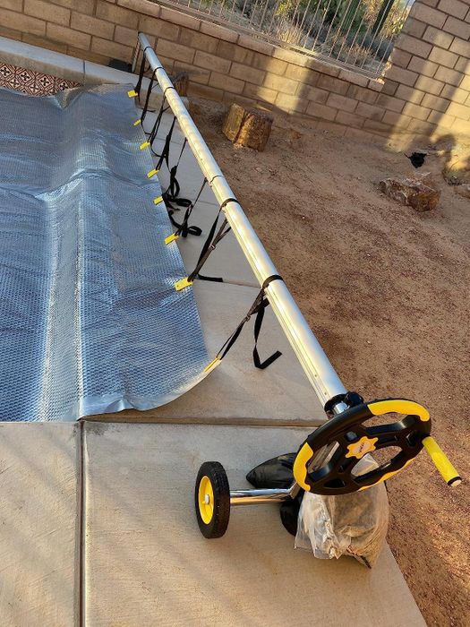 A reviewer's photo showing the pool cover extended over the pool and secured to the cover reel