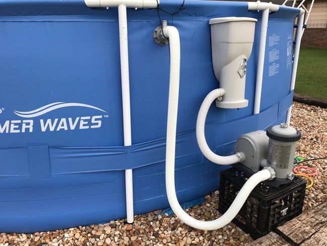 A reviewer's photo showing the pump installed next to an above-ground pool