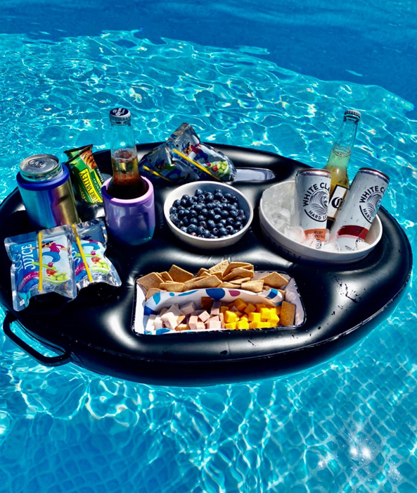 A black float in the pool holding snacks, drinks, and fruit