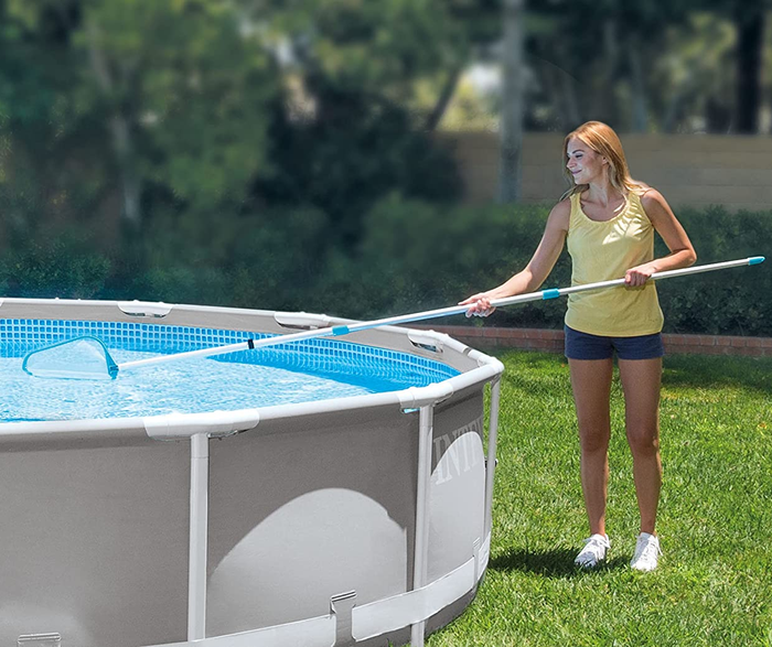 A person using the skimmer net to clean an above-ground pool