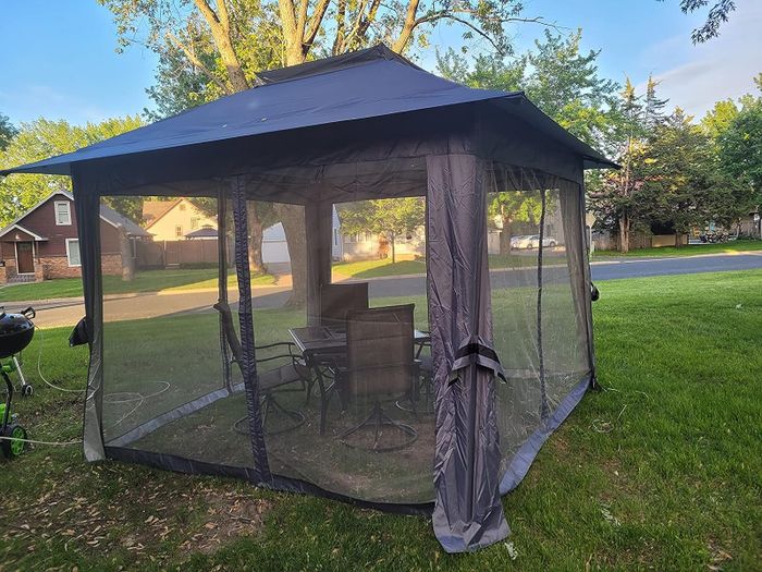 Reviewer's gray gazebo with nets down, enclosing the space.
