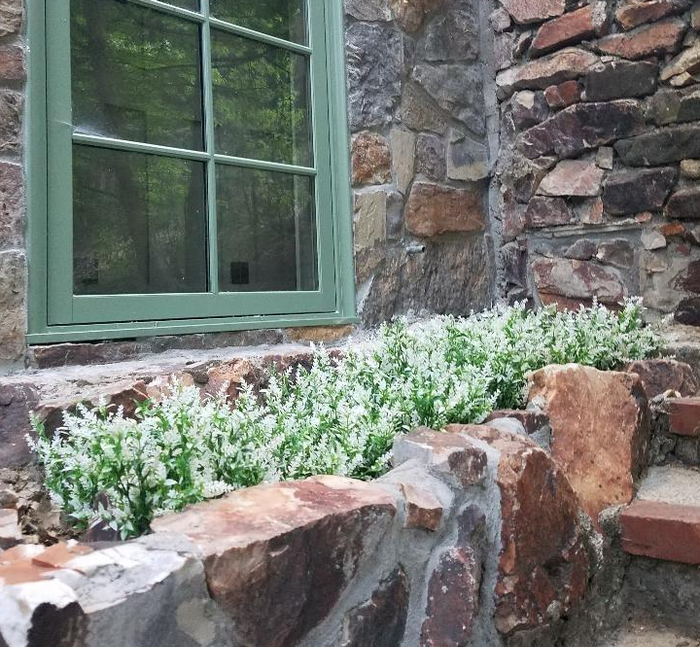 The faux white flowers arranged in a stone planter.