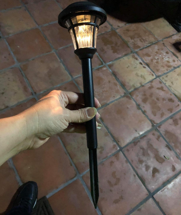 A reviewer holding one of the lights to display its stake.