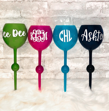 The wine glasses in green, pink, blue, and black, each with a stylish monogram.