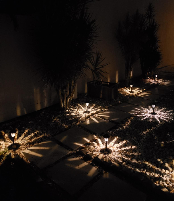 The lights shining brightly in a garden during the night.