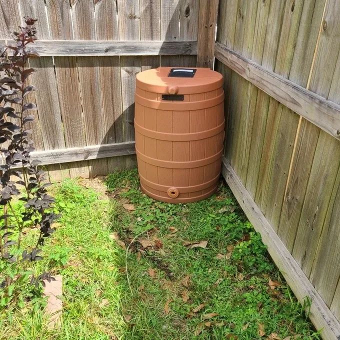 Reviewer image showing the rain barrel set up in their backyard