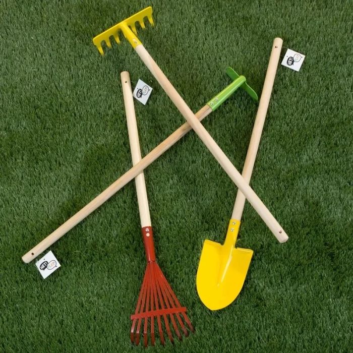 A collection of colorful gardening tools placed on grass