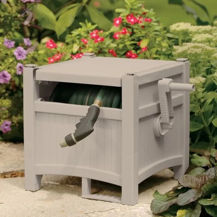 Garden hose reel displayed in a backyard surrounded by lush greenery