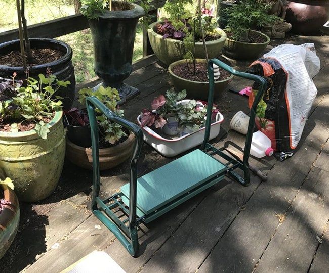 A kneeler bench placed beside potted plants, ready for use