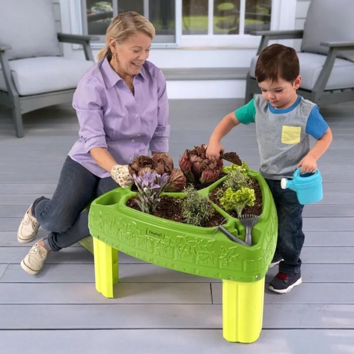 A raised planter with a child and a parent standing next to it