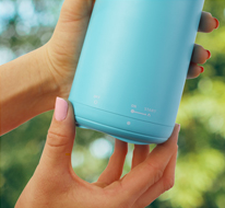 A hand twisting the bottom of the mosquito repellent to activate it