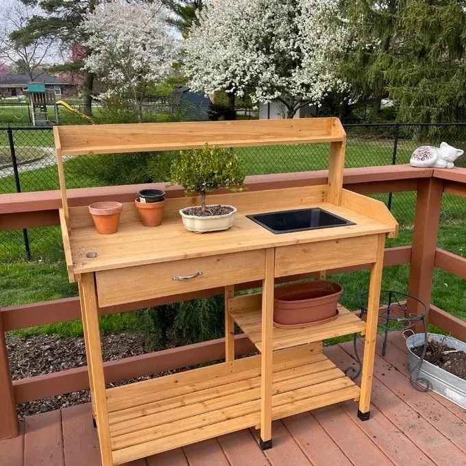 Reviewer's photo showcasing the natural wood potting bench in use on their patio