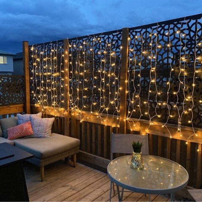 A beautiful porch decorated with string lights, creating a warm, inviting glow at night.