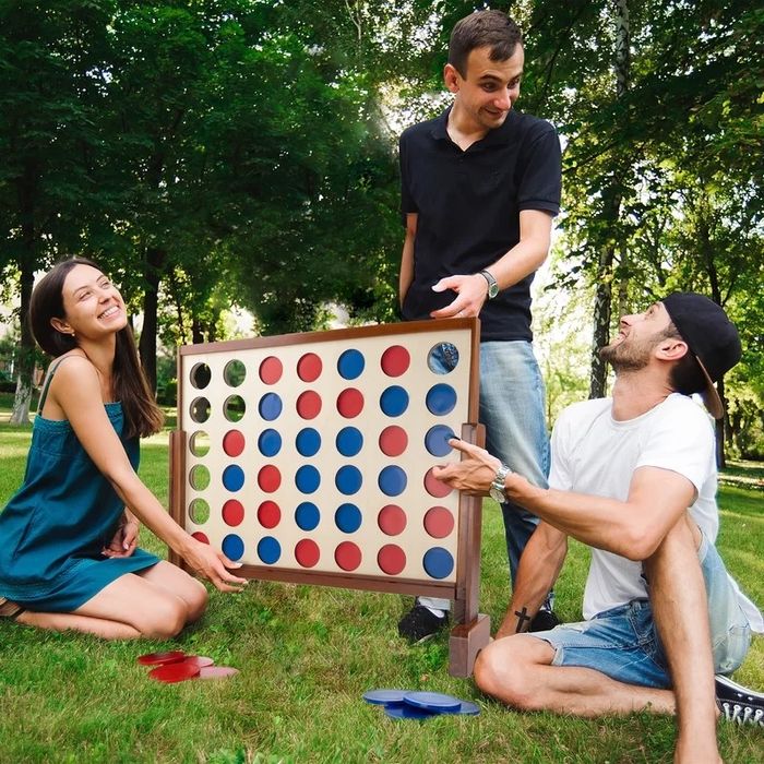 Three people engaged in an exciting round of the 4-in-a-row game.