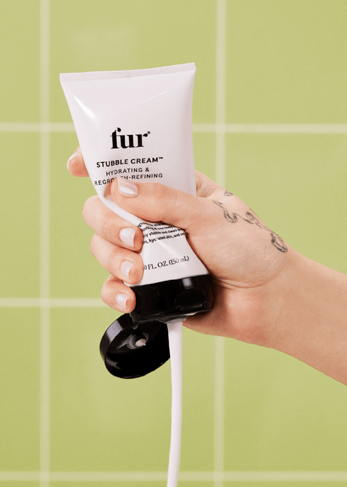 Model applying the Fur Stubble Cream from a white tube