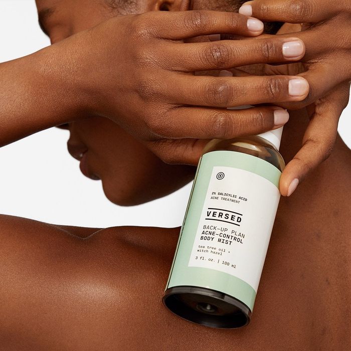 Model holding body mist up to their back